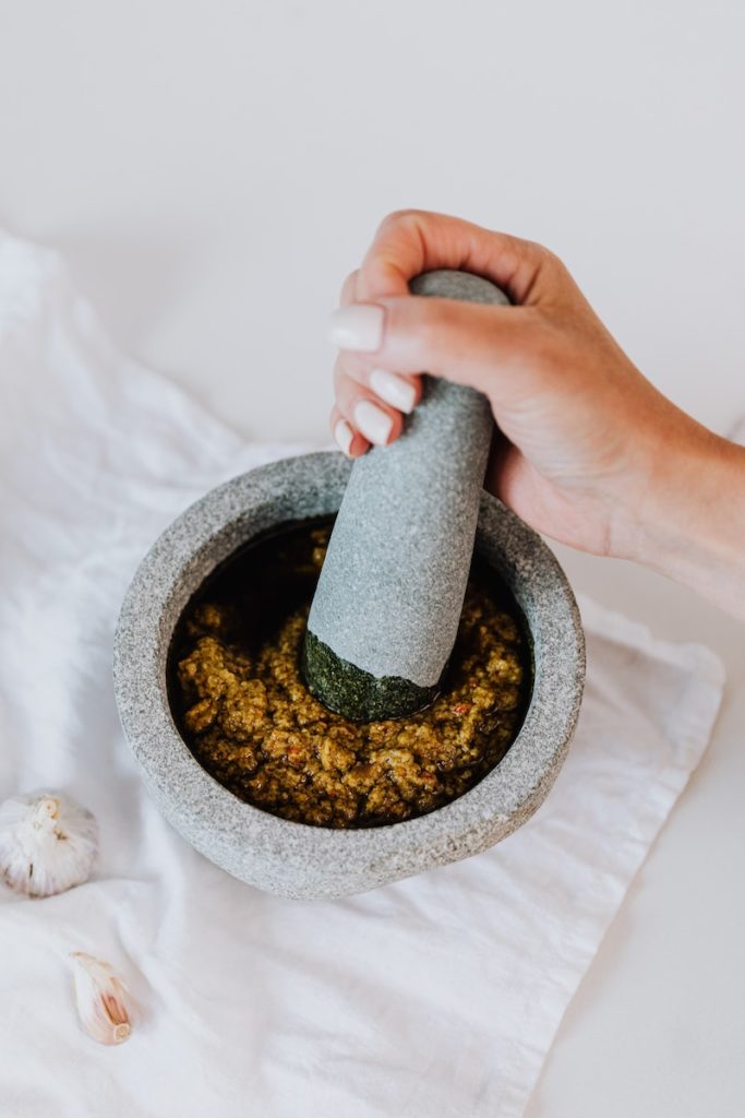 Person Holding Grinding Using Mortar and Pestle