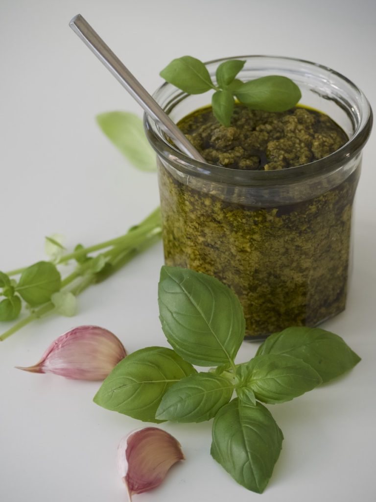 Pesto Sauce in Clear Glass Jar With Basil Leaves